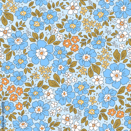 Beautiful floral pattern in small flowers. Small blue and orange  flowers. Light blue background. Liberty print. Floral seamless background. Trendy template for fashion prints. Stock pattern.