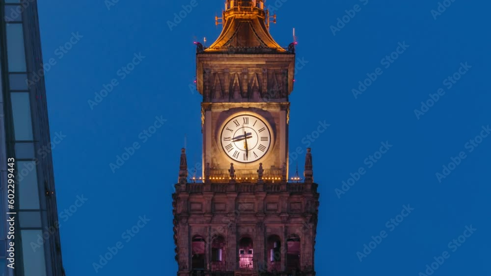 Day to night transition time lapse of illuminated large tower clock on the top of Palace of Culture and Science PKiN in Warsaw city Poland, zoom in effect. Arrow moving fast shows running time