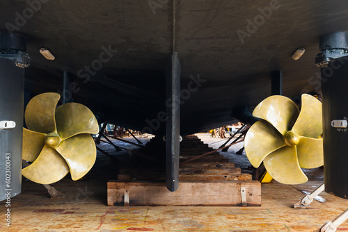 Quadro su tela Aft with two propellers of the luxury motor yacht is dry docked on wooden blocks and supported by steel supports