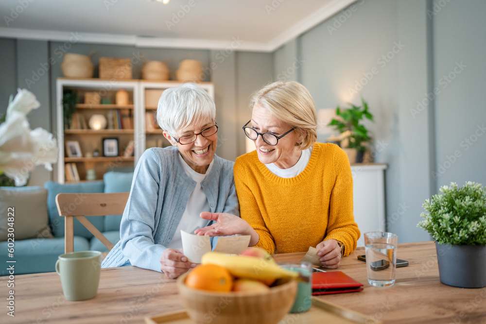 Senior mature women friends or sisters looking family photos album Senior mature women friends or sisters looking family photos album