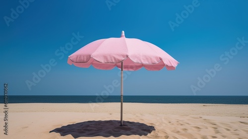Pink beach umbrella in a sandy beach environment with a clear blue sky.