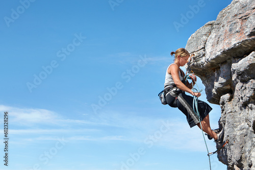 Rock climbing, blue sky and freedom with woman on mountain cliff for adventure or travel with space. Strong, challenge and mockup with female climber training in nature for courage, safety or workout