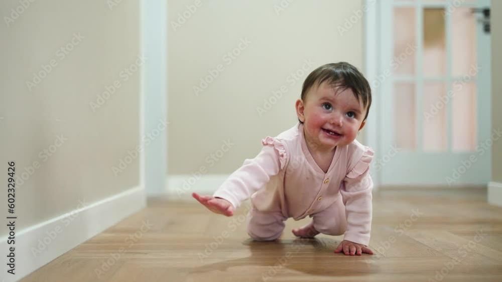 Happy and curious child explores his house by crawling on parquet floor. Happiness and satisfaction on face of child. Baby crawls across floor towards his parent. Baby learns to move on floor at home Happy and curious child explores his house by crawling on parquet floor. Happiness and satisfaction on face of child. Baby crawls across floor towards his parent. Baby learns to move on floor at home