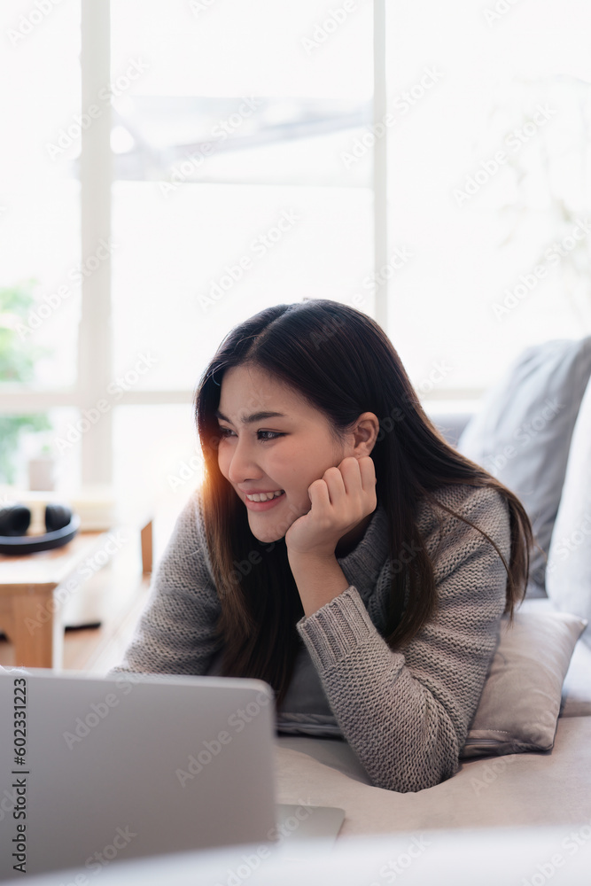 Attractive Asian woman resting comfortable living room and using laptop computer, Relax, Sofa, Lifestyle Attractive Asian woman resting comfortable living room and using laptop computer, Relax, Sofa, Lifestyle