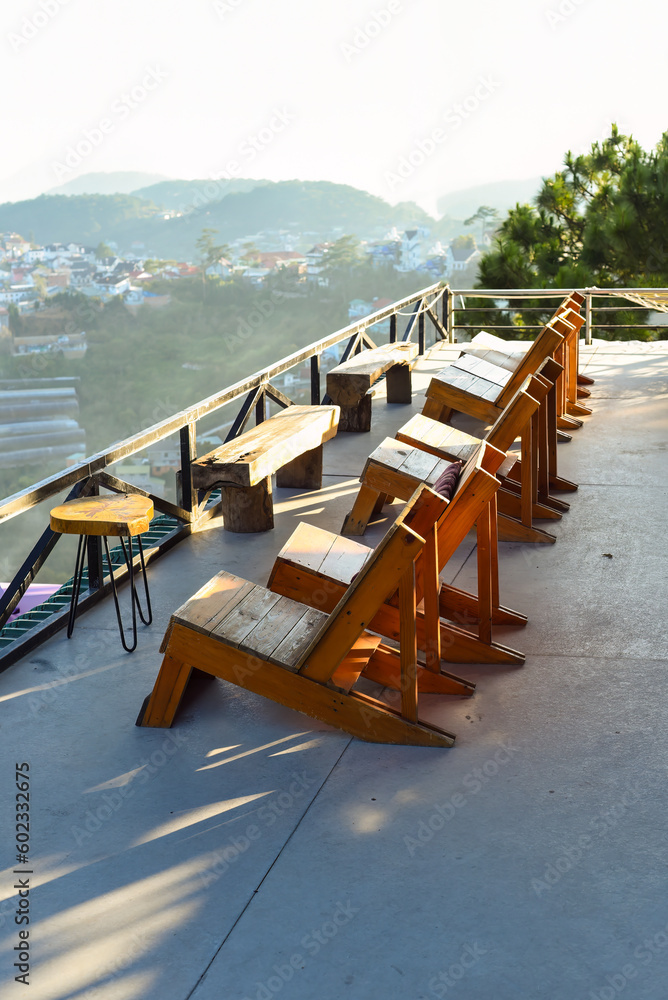 Wooden chairs without people against sunset in mountains of Da Lat in Vietnam