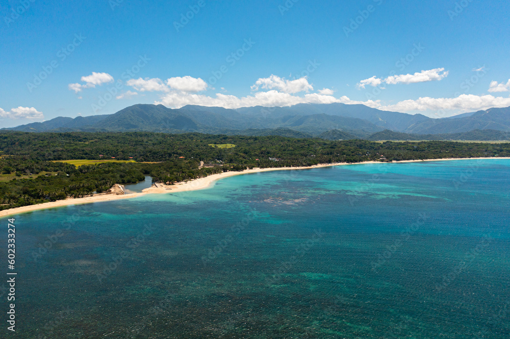 Seascape with tropical sandy beach and blue ocean. Pagudpud, Ilocos Norte, Philippines.