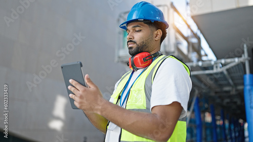 African american man builder using touchpad at street