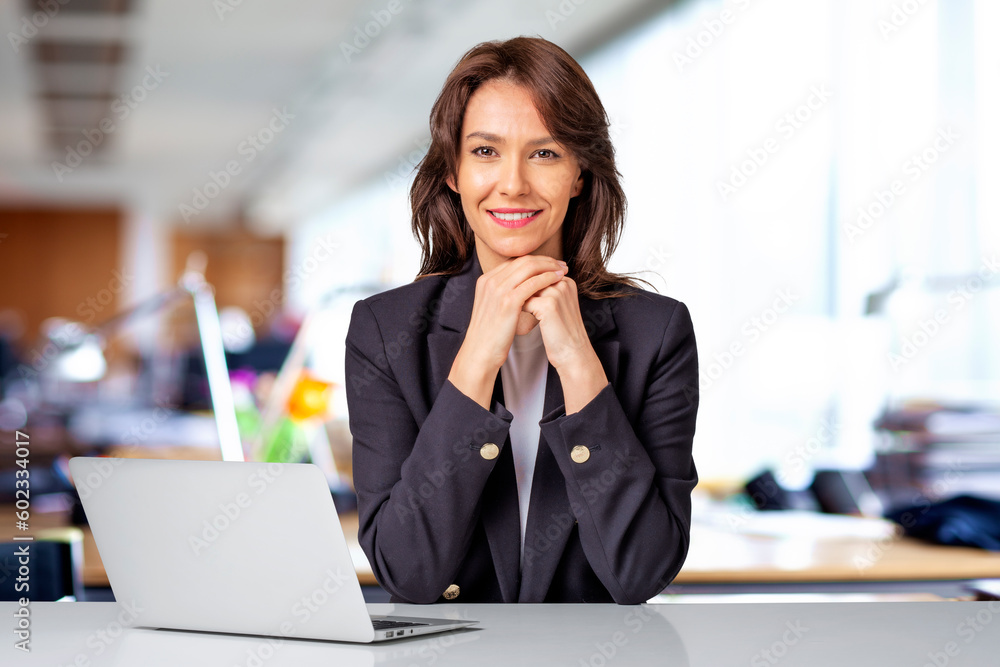Portrait of confident businesswoman sitting at the office and using laptop for work Portrait of confident businesswoman sitting at the office and using laptop for work