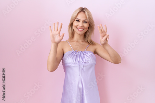 Young caucasian woman wearing lingerie dress showing and pointing up with fingers number eight while smiling confident and happy.