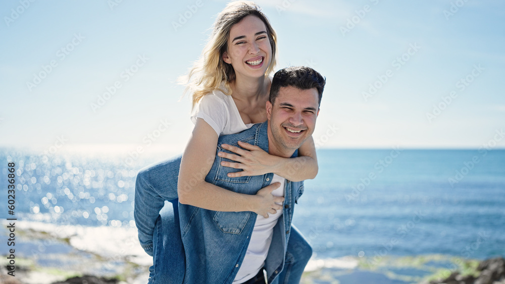 Man and woman couple smiling confident standing on back at seaside
