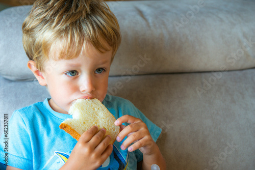 Tablou canvas enfant en train de manger une tranche de brioche à la maison