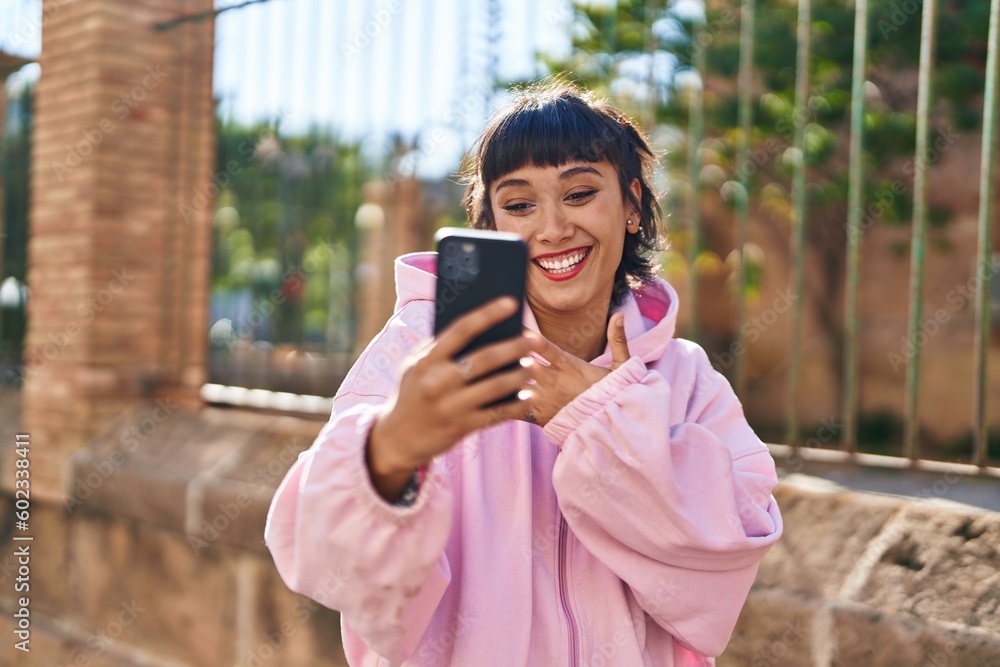 Young woman smiling confident having video call at street