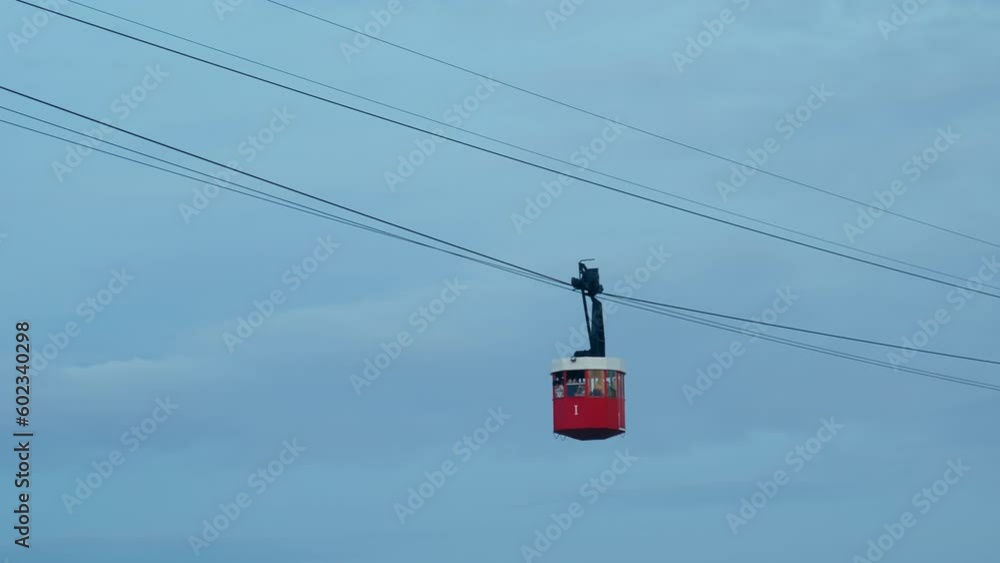 Against the overcast background, red funicular cable car offers a scenic touristic ride to reach destination. Public transportation and recreational experience, perfect vacation. Against the overcast background, red funicular cable car offers a scenic touristic ride to reach destination. Public transportation and recreational experience, perfect vacation.