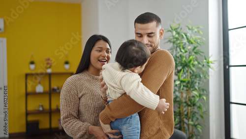 Couple and son hugging each other standing at home