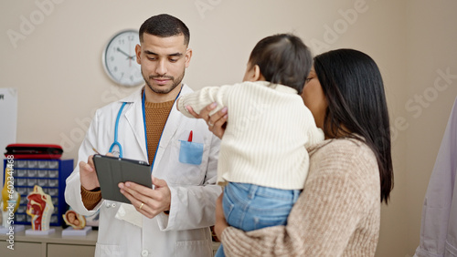 Fényképezés Couple and son having medical consultation writing on touchpad at clinic
