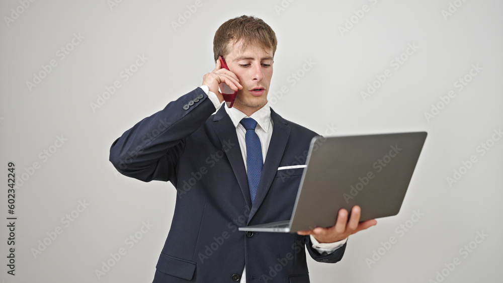 Young caucasian man business worker using laptop talking on smartphone over isolated white background Young caucasian man business worker using laptop talking on smartphone over isolated white background
