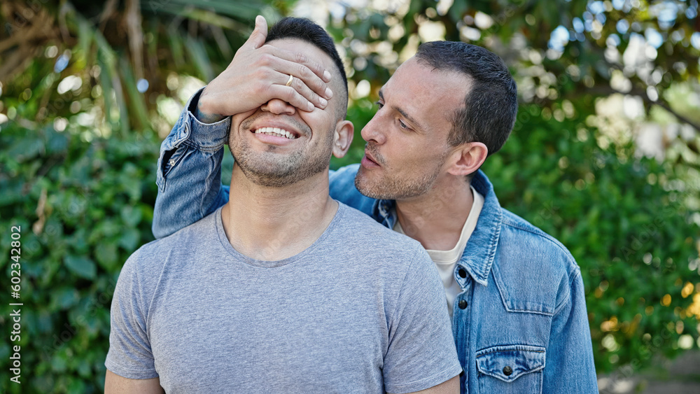 Two men couple covering eyes with hand for surprise at park