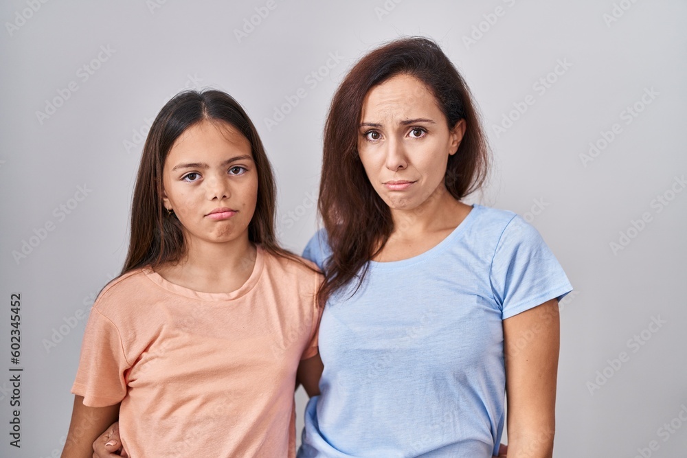 Young mother and daughter standing over white background depressed and worry for distress, crying angry and afraid. sad expression. Young mother and daughter standing over white background depressed and worry for distress, crying angry and afraid. sad expression.