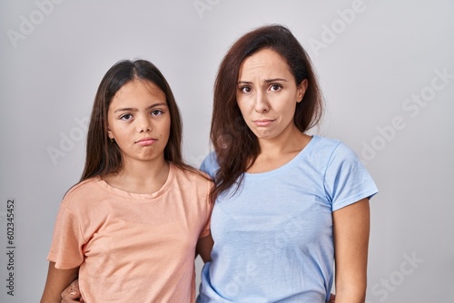 Young mother and daughter standing over white background depressed and worry for distress, crying angry and afraid. sad expression.