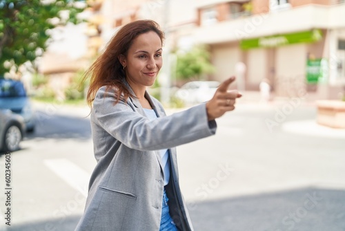 Young woman executive pointing with finger at street © Krakenimages.com