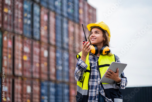 Beautiful female worker working in a safety suit at a port warehouse. Security check in port warehouse. Transport, import, export. Logistics concept. Industry.