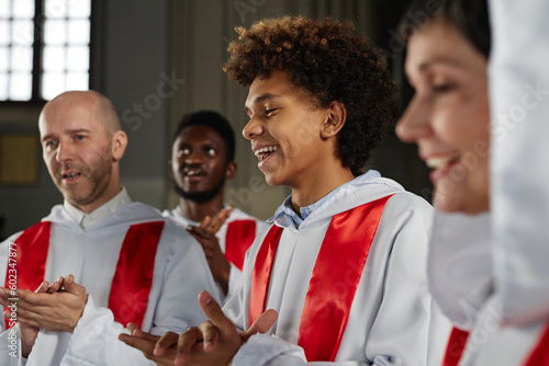 Canvas-taulu Group of happy people from church choir singing and clapping hands during perfor