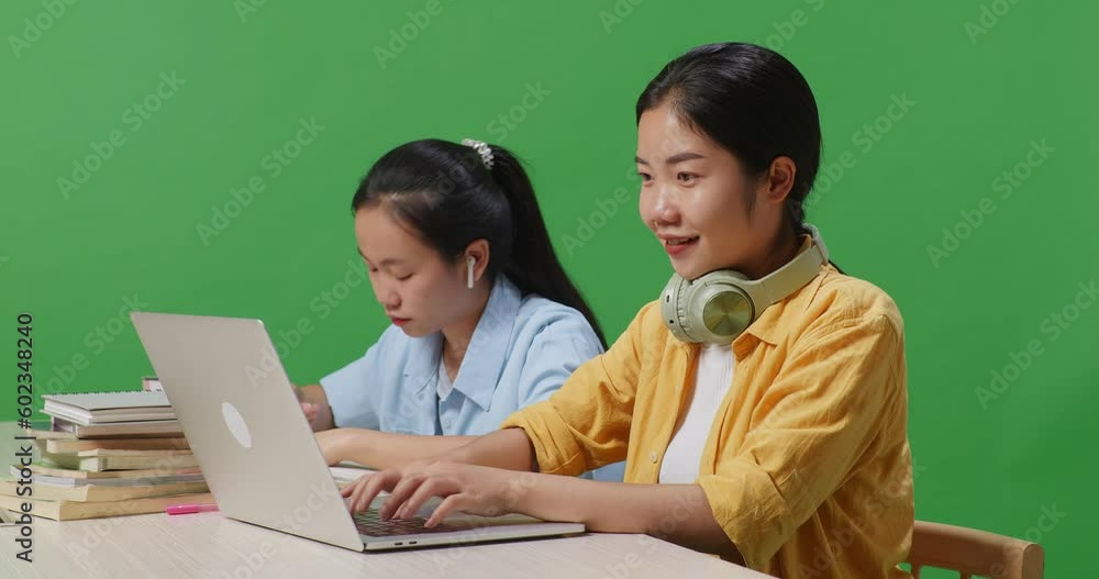 Close Up Of Asian Woman Student Typing On A Laptop And Smiling To Camera While Sitting With Her Friend Studying On A Table In The Green Screen Background Classroom
Close Up Of Asian Woman Student Typing On A Laptop And Smiling To Camera While Sitting With Her Friend Studying On A Table In The Green Screen Background Classroom