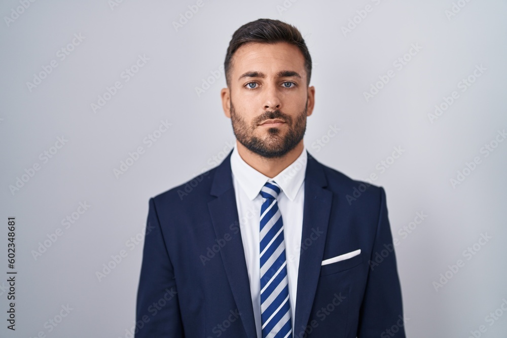 Handsome hispanic man wearing suit and tie relaxed with serious expression on face. simple and natural looking at the camera. Handsome hispanic man wearing suit and tie relaxed with serious expression on face. simple and natural looking at the camera.