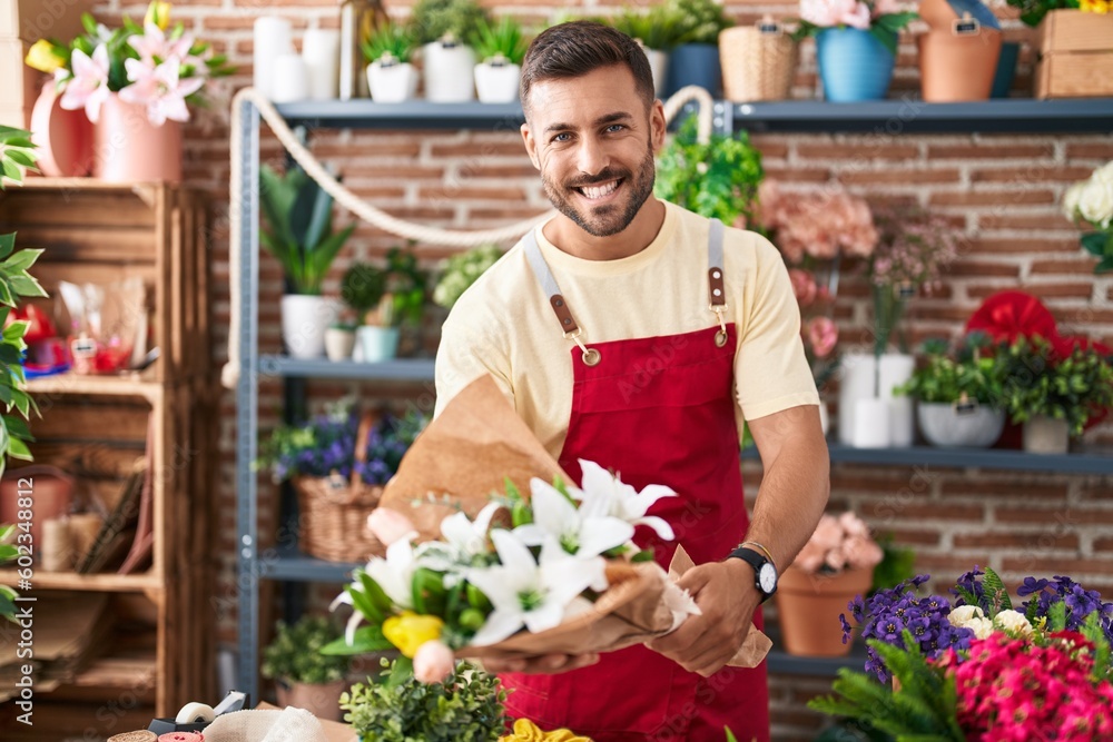 Young hispanic man florist holding bouquet of flowers at florist Young hispanic man florist holding bouquet of flowers at florist