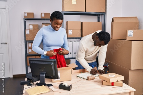 Man and woman ecommerce business workers prepare sweater order at office