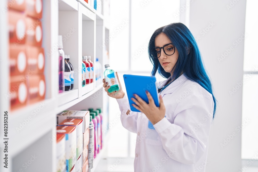 Young caucasian woman pharmacist using touchpad holding medicine at pharmacy