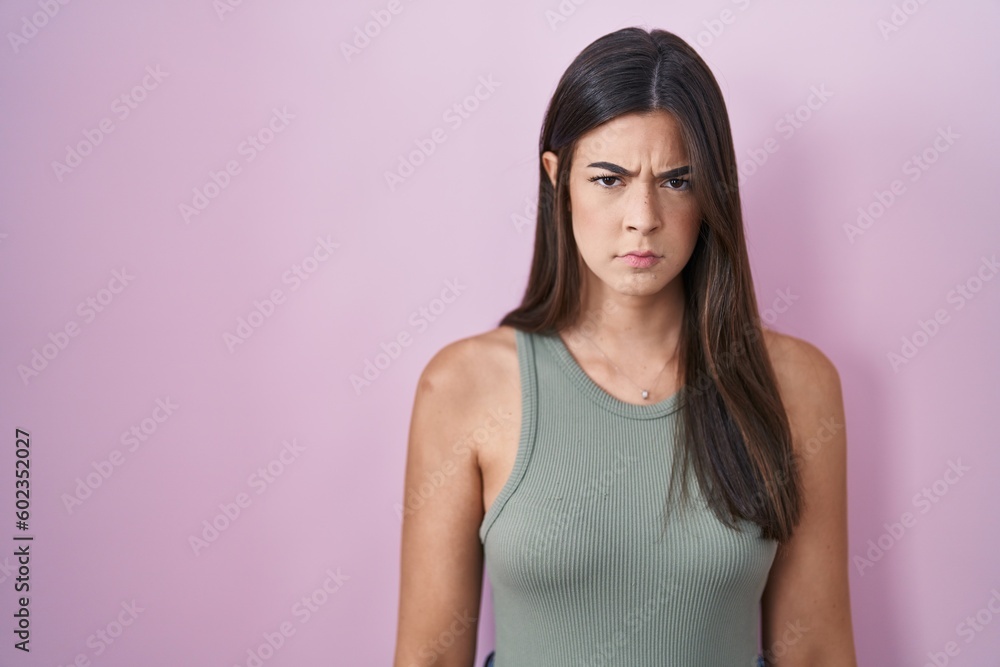 Hispanic woman standing over pink background skeptic and nervous, frowning upset because of problem. negative person. Hispanic woman standing over pink background skeptic and nervous, frowning upset because of problem. negative person.
