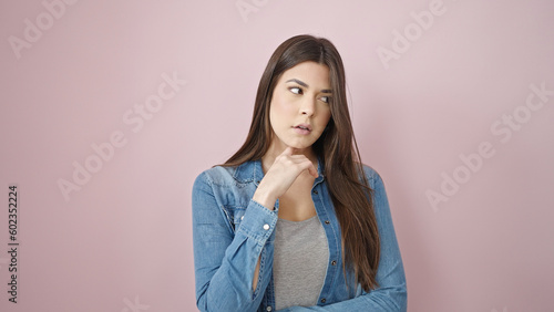 Young beautiful hispanic woman looking to the side with doubt expression at park