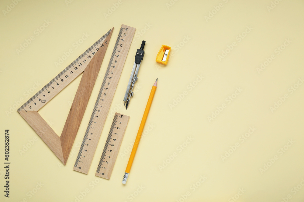 Different rulers, pencil, and compass on yellow background. Space for text Different rulers, pencil, and compass on yellow background. Space for text