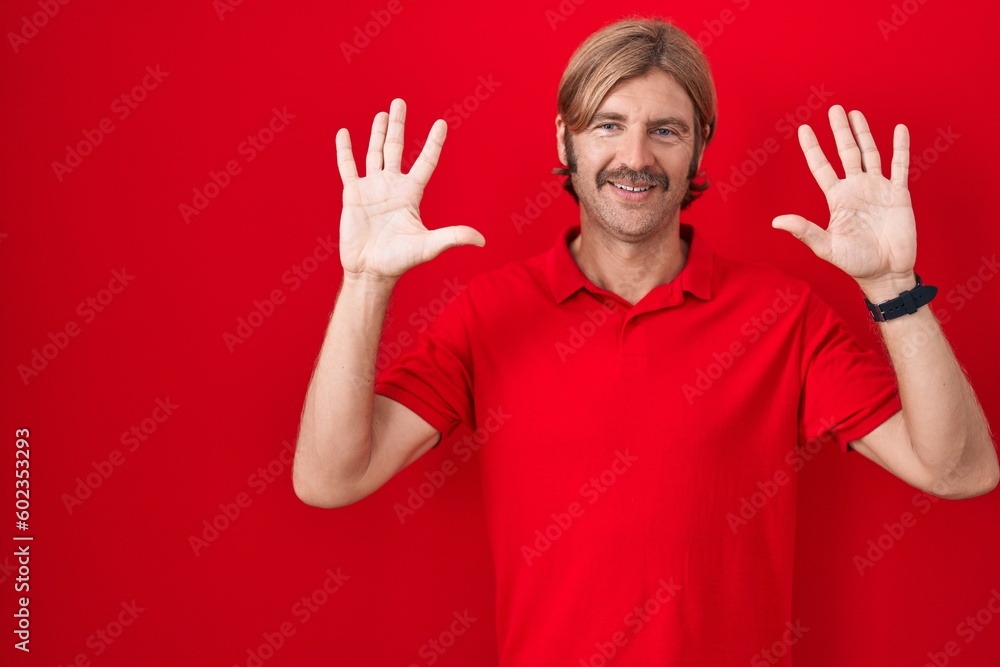 Caucasian man with mustache standing over red background showing and pointing up with fingers number ten while smiling confident and happy. Caucasian man with mustache standing over red background showing and pointing up with fingers number ten while smiling confident and happy.
