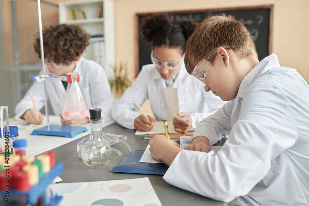 Side view portrait of schoolboy in science class with group of children, copy space Side view portrait of schoolboy in science class with group of children, copy space