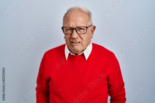 Senior man with grey hair standing over isolated background skeptic and nervous, frowning upset because of problem. negative person.