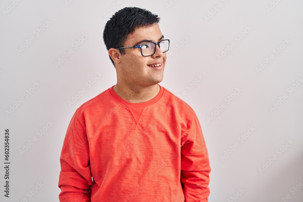 Young hispanic man with down syndrome standing over white background looking to side, relax profile pose with natural face and confident smile. Young hispanic man with down syndrome standing over white background looking to side, relax profile pose with natural face and confident smile.