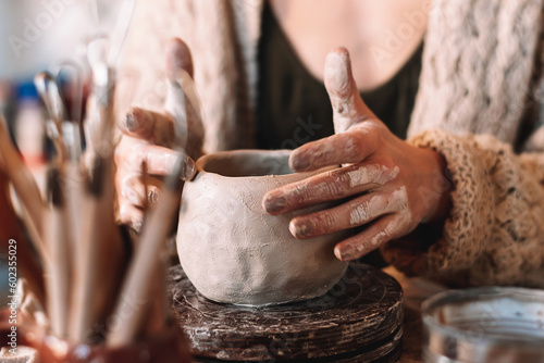 Obraz na płótnie Female sculptor making clay mug in a home workshop,hands close-up.Small business,entrepreneurship,hobby, leisure concept. w salonie