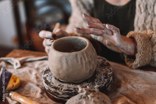 Female sculptor making clay mug in a home workshop,hands close-up.Small business,entrepreneurship,hobby, leisure concept.
