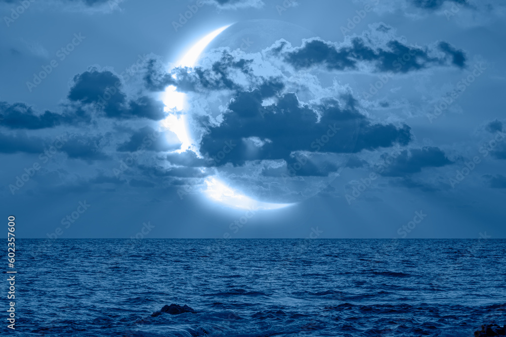 Abstract blue background - Night sky with crescent in the clouds over the blue sea at sunset 