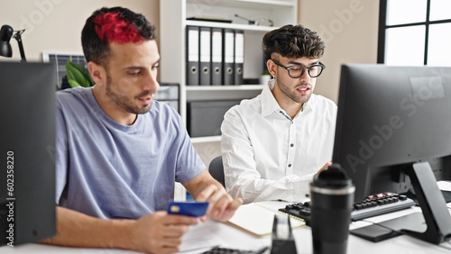 Two men business workers using computer and credit card at office