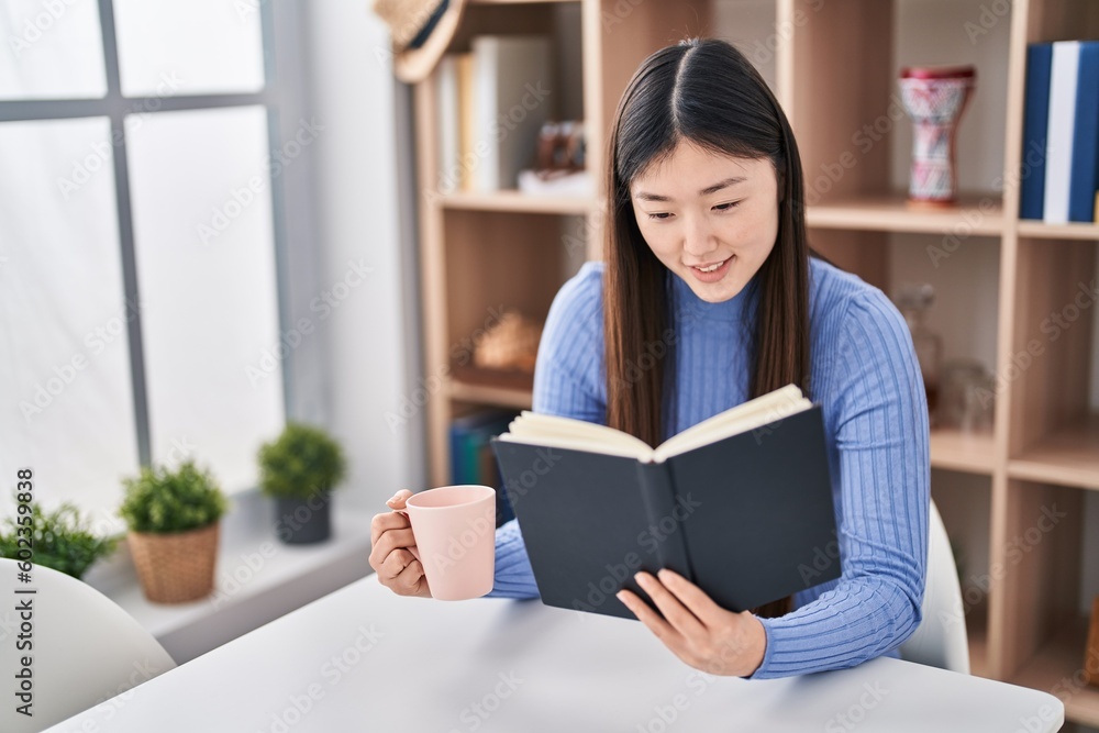 Chinese woman reading book and drinking coffee at home Chinese woman reading book and drinking coffee at home