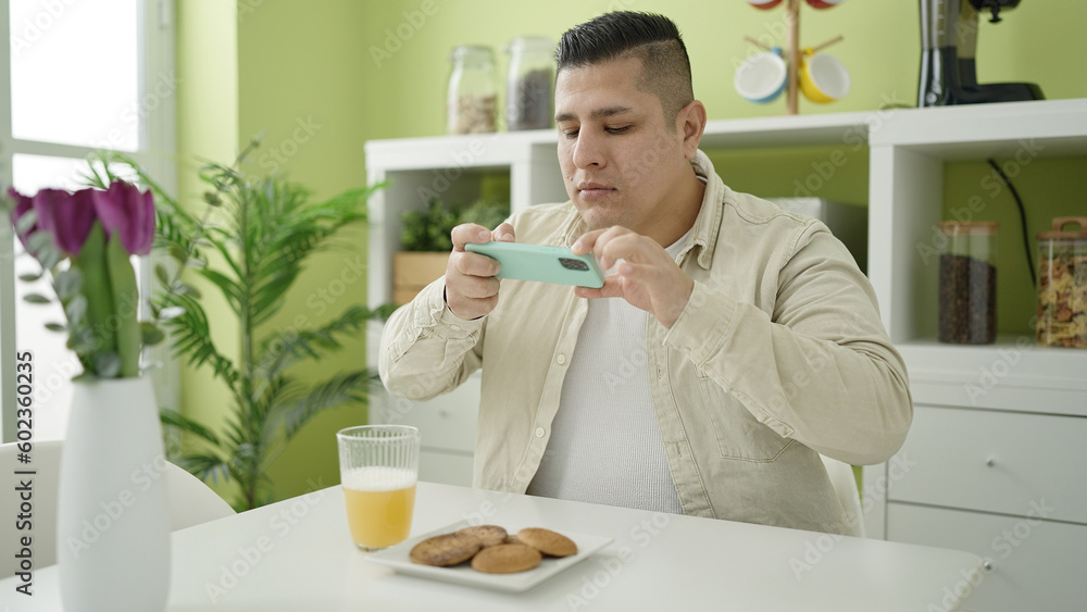 Young hispanic man make photo by smartphone to breakfast at dinning room Young hispanic man make photo by smartphone to breakfast at dinning room