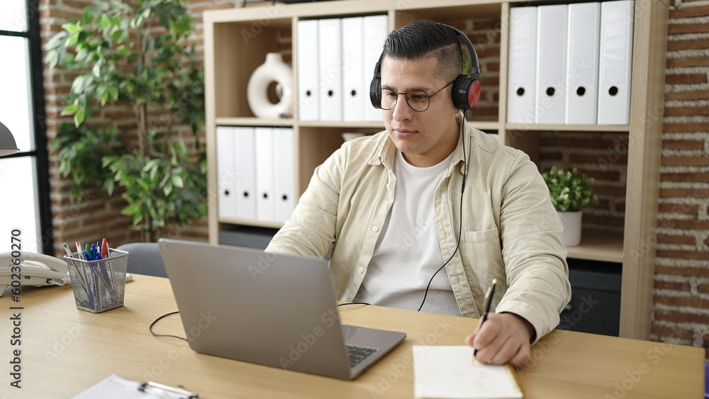 Young hispanic man business worker using laptop wearing headphones at office Young hispanic man business worker using laptop wearing headphones at office