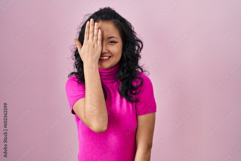 Young asian woman standing over pink background yawning tired covering half face, eye and mouth with hand. face hurts in pain. Young asian woman standing over pink background yawning tired covering half face, eye and mouth with hand. face hurts in pain.