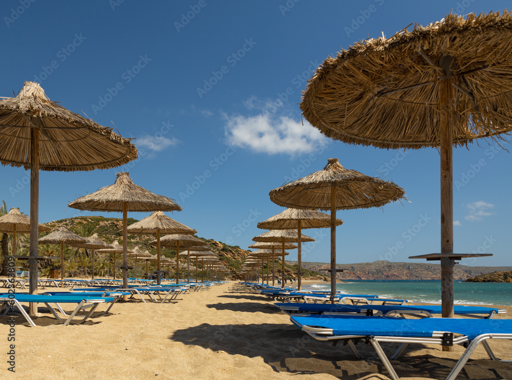 The sandy beach of Vai and empty umbrellas at the beginning of the tourist season on the southern coast of Crete, Greece