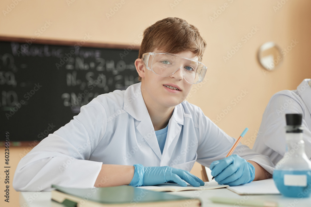 Portrait of teenage boy wearing braces in science class at school and looking at camera Portrait of teenage boy wearing braces in science class at school and looking at camera