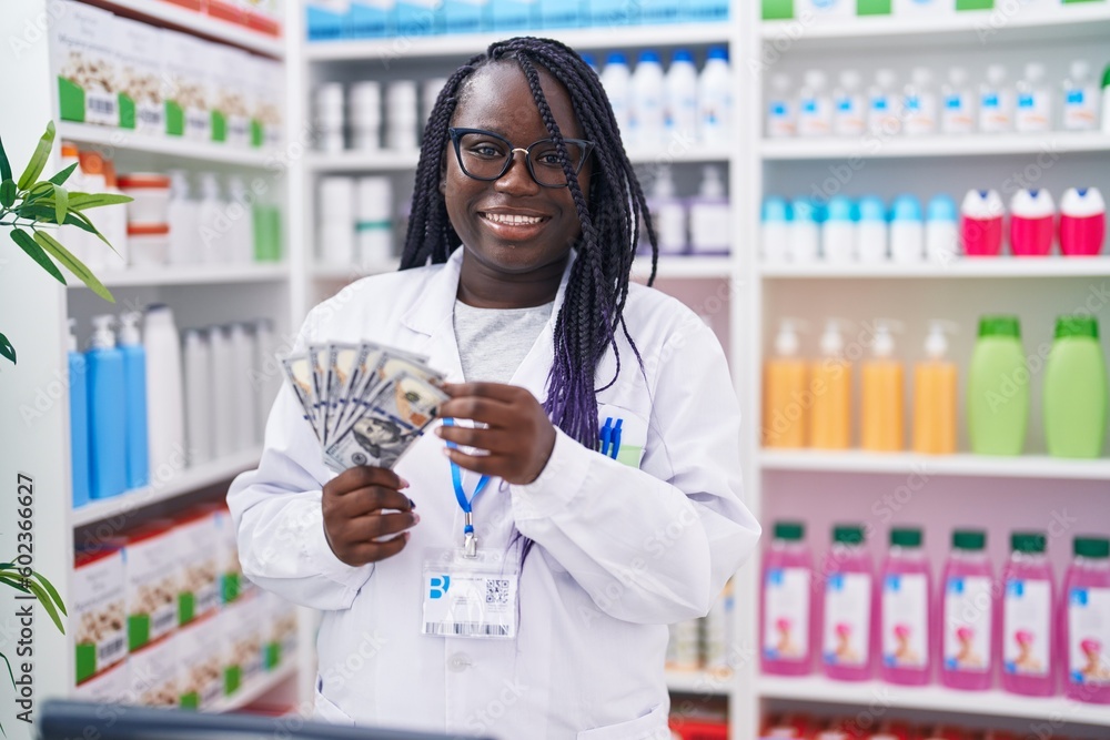 African american woman pharmacist smiling confident counting dollars at pharmacy