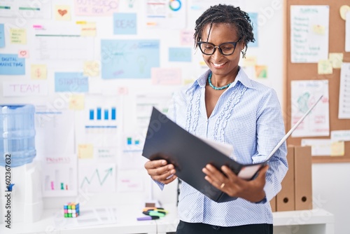 Middle age african american woman business worker reading document at office